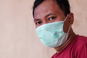 Asian man wearing a medical face mask, suitable to illustrate how to prevent every people from attack deadly diseases outbreak like coronavirus or covid-19, which become a world pandemic.