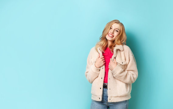 Beautiful Young Woman In Coat On Blue Background