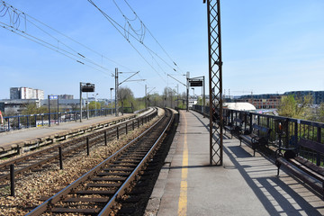 Fototapeta na wymiar Railway at the suburban train station. In the background is the city.