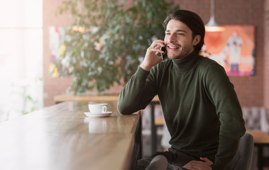 Young successful businessman talking to clients on phone