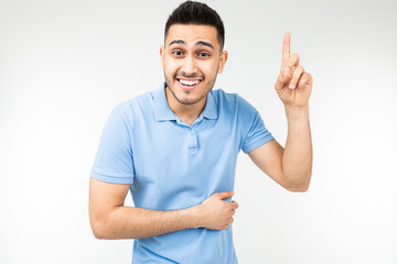 Fototapeta premium Caucasian man in a blue T-shirt offers an idea showing thumb up on a white background