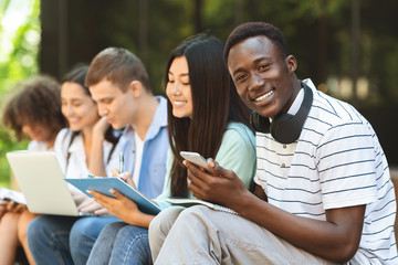 Happy African American Teen Guy Studying With His College Friends Outdoor