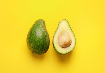 Green ripe avocado on yellow background. Top view