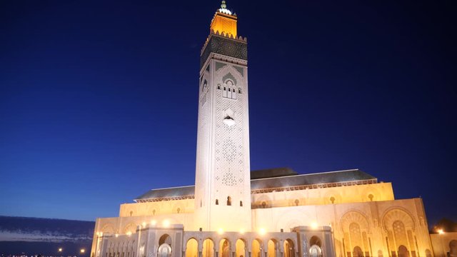 tilt up clip of the hassan ii mosque and its minaret at night in casablanca, morroco