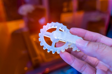 hand with Object of gear printed on 3d printer close-up