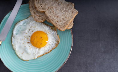 Breakfast fried sunny side up egg with whole grain bread.