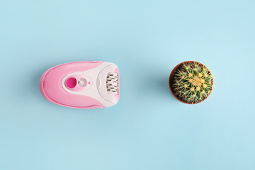 Pink epilator with flowers on  blue background. Depilation concept.