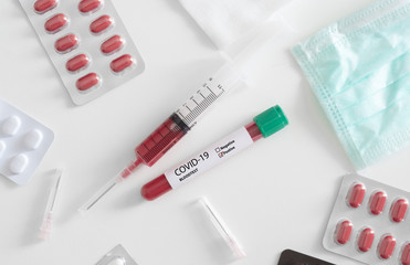 top view of Covid-199 Blood test concept with syringe, Medical Mask, medicine and test tube on white table background