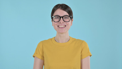 The Cheerful Young Woman Looking at the Camera and Smiling on Blue Background