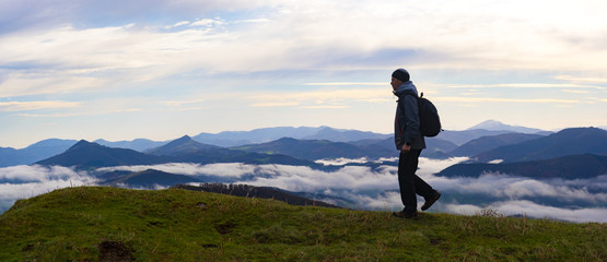 Hiker contemplating the mountains with sea of clouds from the natural park of Aiako Harriak, Euskadi