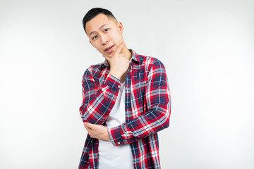 Confident Asian man in a plaid shirt wide open on a white studio background with copy space