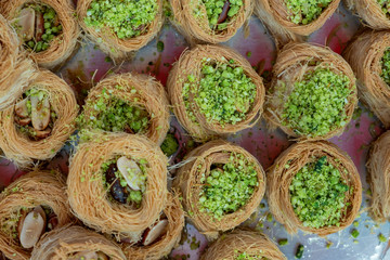 Traditional arabic and turkish sweets pastry dessert kadaif (kunafa, baklava), with pistachio, sold at local market