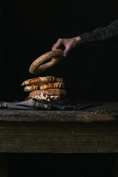 A Hand Taking a Bagel on a Black Background