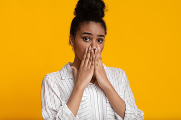 Oh No. Shocked afro woman covering her mouth with hands