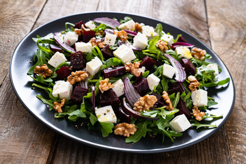  Beetroot salad with goat cheese on wooden background