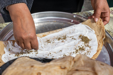 Fototapeta na wymiar Homemade arabian flatbread (other names is pita, lavash, lafa, parantha, roti, chapati) with olive oil, zaatar and labneh (strained yogurt)