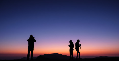 Ambaritsa peak, Bulgaria - October 20, 2019. Group of climbers welcoming the sunset from the top f Ambaritsa peak, Central Balkan national park. Botev peak at the bottom of the horizon.