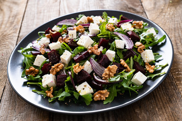 Beetroot salad with goat cheese on wooden background