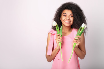 Young african woman with flowers on white background. Women's day concept