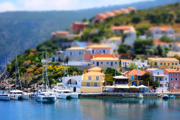 Fototapeta na wymiar Soft focus and tilt shift blur. Colorful Asos village at Kefalonia island. Greece. Popular destination on Ionian Sea for vacation. Mediterranean port for traveling by yacht and honeymoon paradise