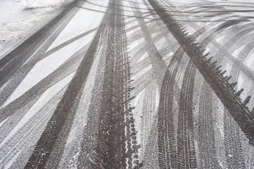 Tire tracks on a city road covered by snow. Cold winter day.