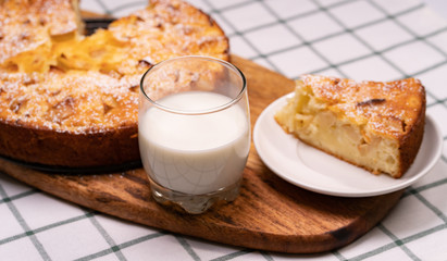 cut off part homemade cake and glass milk wooden