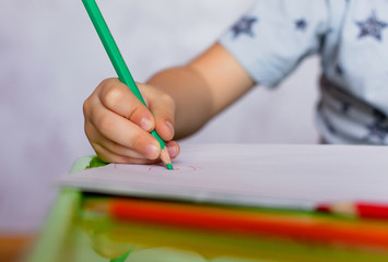 Close-up of childs hands drawing. Boy, drawing a picture for fathers day. Small boy draws at the table.