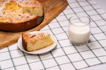 cut off part homemade cake and glass milk wooden