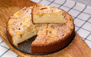 cut off part homemade cake pan on wooden Board. 