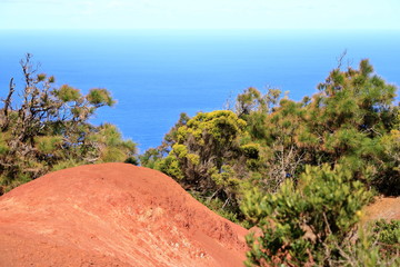 Colorful red earth and sand hills of volcanic origin above 