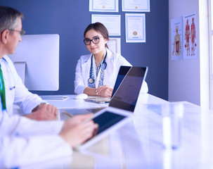 Fototapeta premium Serious medical team using a laptop in a bright office