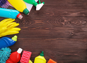 Cleaning product plastic containers for house clean on wooden table. Top view. Copy space