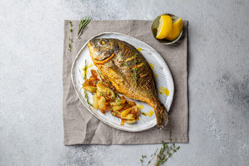 Grilled sea bream or dorada on gray plate. Gray background