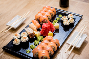 Sushi set. Rolls with salmon, eel and red caviar on a wooden plate. Restaurant.