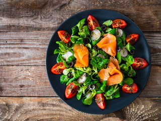 Salmon salad - smoked salmon and vegetables on wooden background