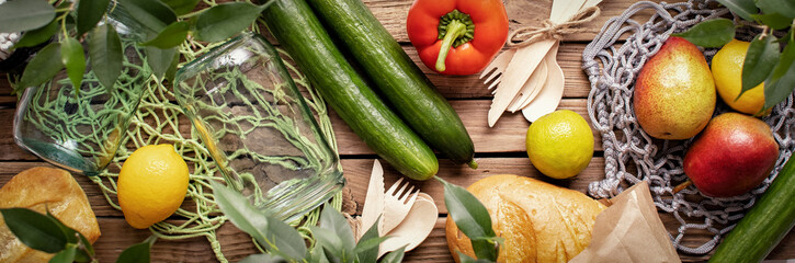 Concept of zero waste, environmental friendly products with glass jars and net bags on wooden background.