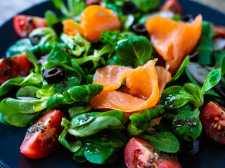 Salmon salad - smoked salmon and vegetables on wooden background