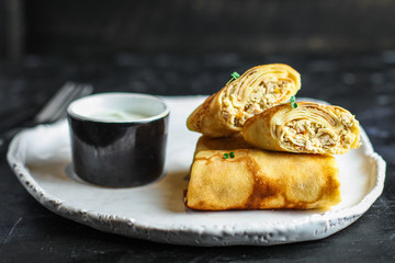 thin pancakes or crepes stuffed chicken meat and vegetables (hen or turkey) menu concept background. top view. copy space for text