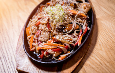 Chinese noodles with mussels and shrimps on the wooden table.