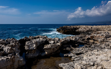 Waves crash on the rocky shore of the Mediterranean Sea on the Akamas Peninsula in the northwest of the island of Cyprus.