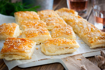 Puff pastry pie with cheese, sprinkled with sesame seeds, selective focus