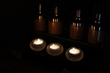 table with massage jars and candles in the dark