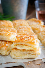 Puff pastry pie with cheese, sprinkled with sesame seeds, selective focus