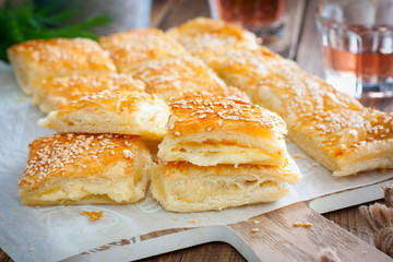 Puff pastry pie with cheese, sprinkled with sesame seeds, selective focus