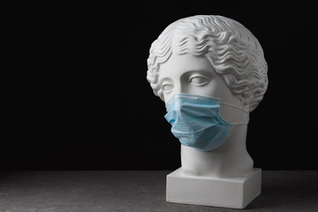 Medical mask on an antique statue. Virus epidemic medical care
