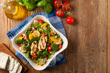 Traditional Greek salad with grilled Halloumi cheese with basil. Top view. Flat lay.
