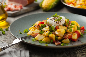Traditional American hash with fried eggs. Front view.