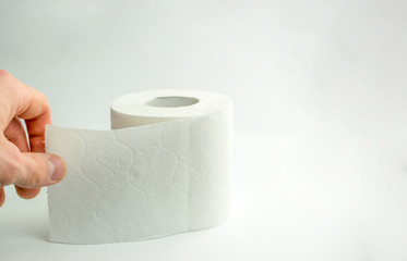 The man rips off a piece of toilet paper.