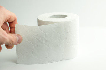 The man rips off a piece of toilet paper.