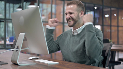 Success Man Celebrating while Working on Computer